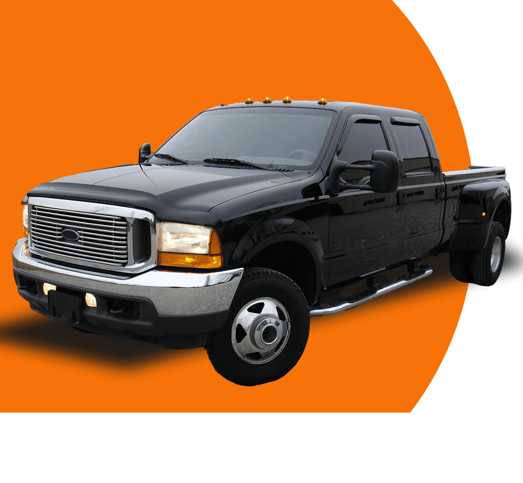 A black truck is parked on the side of a road.