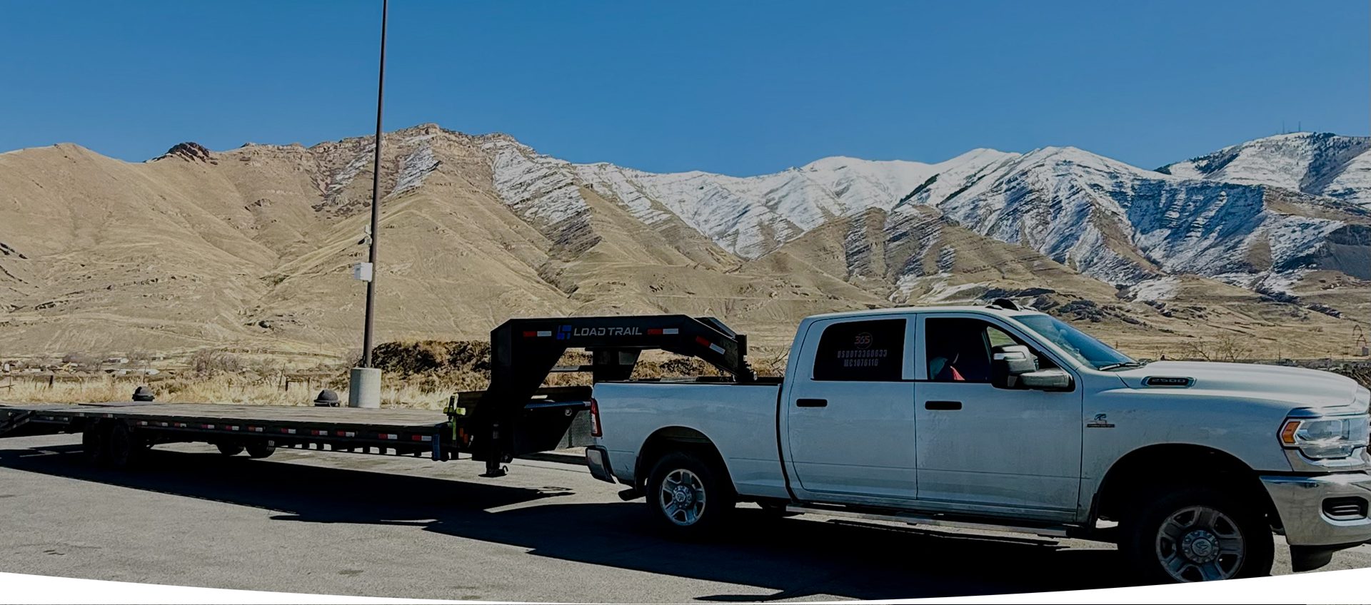 A white truck with a crane on the back of it.